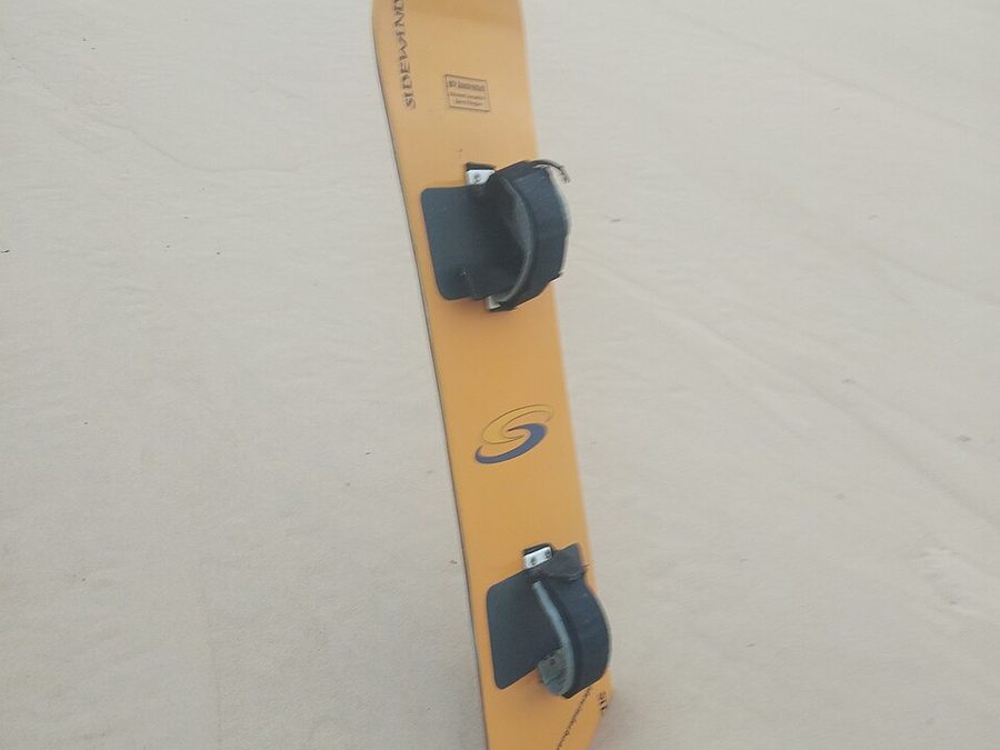 Sandboard resting on a dune
